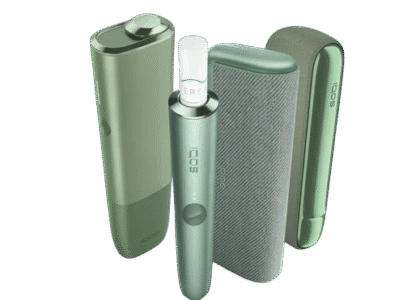 Sleek white IQOS heated tobacco device with holder and charger
